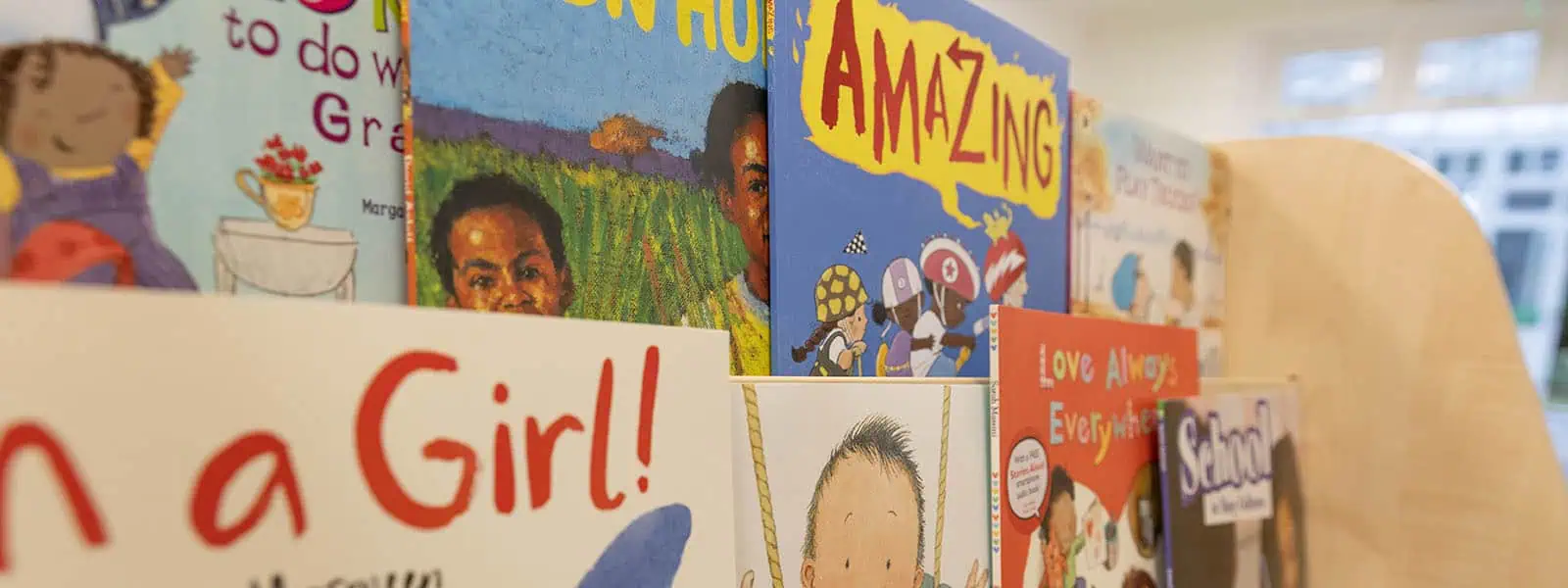 Colorful children's books displayed at Monkey Puzzle Day Nursery & Preschool Lightwater, promoting early childhood literacy and fostering a love for reading in a nurturing learning environment.