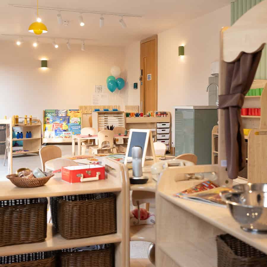 Bright indoor preschool classroom at Monkey Puzzle Day Nursery Lightwater with children’s toys, art supplies, and activity stations for early childhood development and learning in a welcoming environment.