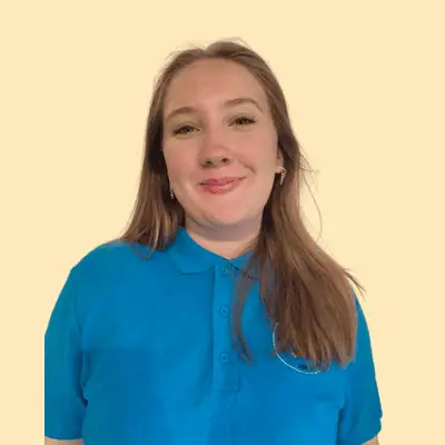Bright young girl smiling in a Monkey Puzzle Day Nursery & Preschool Lightwater uniform, showcasing a welcoming environment for early childhood education and care.