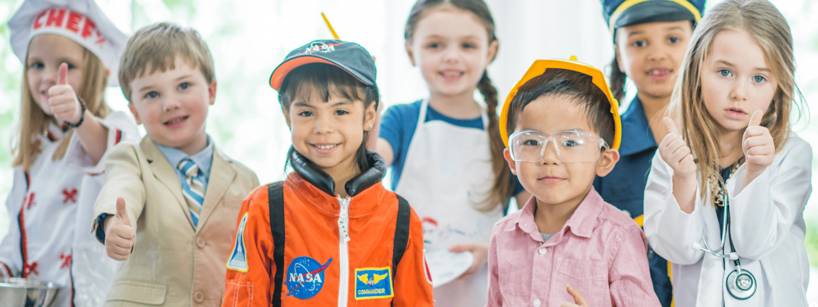 Bright young children in themed costumes and uniforms, representing fun learning activities at Monkey Puzzle Day Nursery & Preschool Lightwater, emphasizing early childhood education and care.